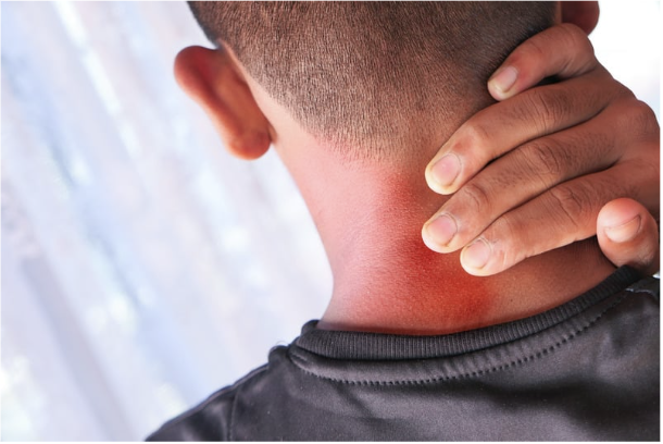 man standing and holding his neck that appears to be aching